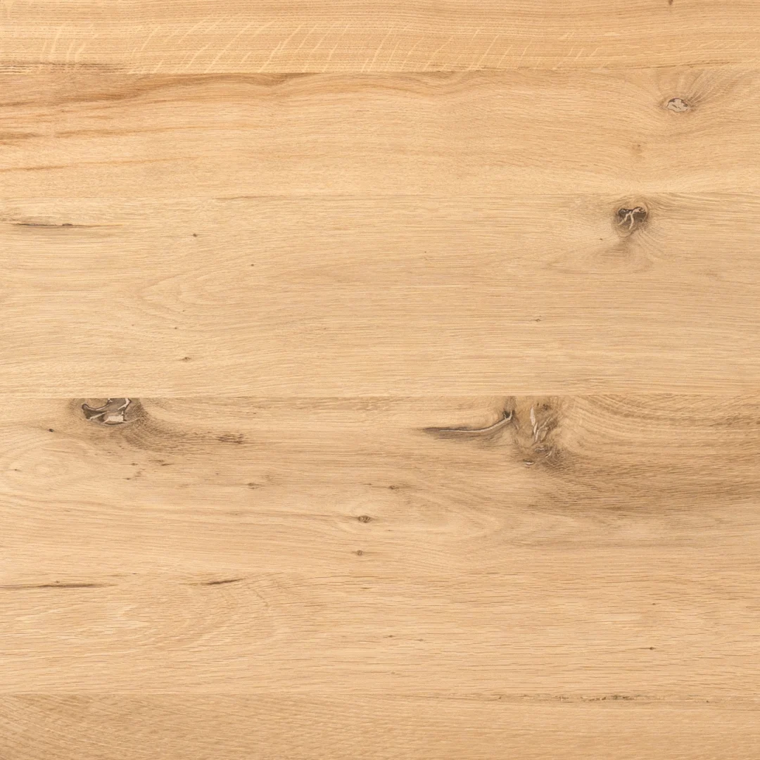 De Eiken eettafel Ferris | Rond 130 cm | Naturel heeft een lichtgekleurd houten oppervlak met zichtbare natuurlijke nerven, knoesten en subtiele toonvariaties, wat de gladde, onafgewerkte textuur benadrukt voor een natuurlijke uitstraling.