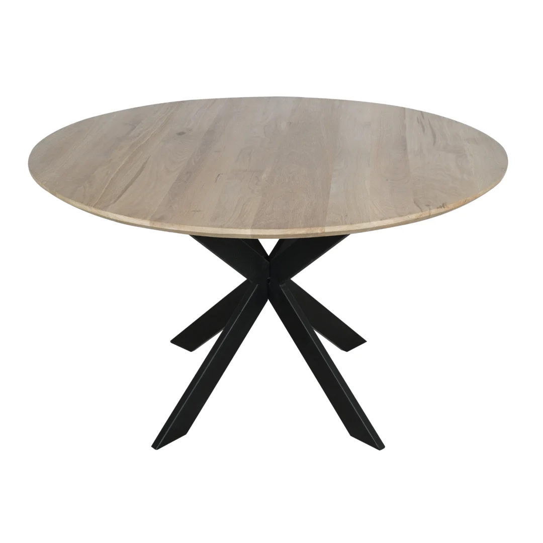 De Eiken eettafel Ferris is een ronde eettafel van 130 cm met een naturel lichtbruin houten blad en een modern zwart metalen onderstel met vier elkaar kruisende schuine poten.