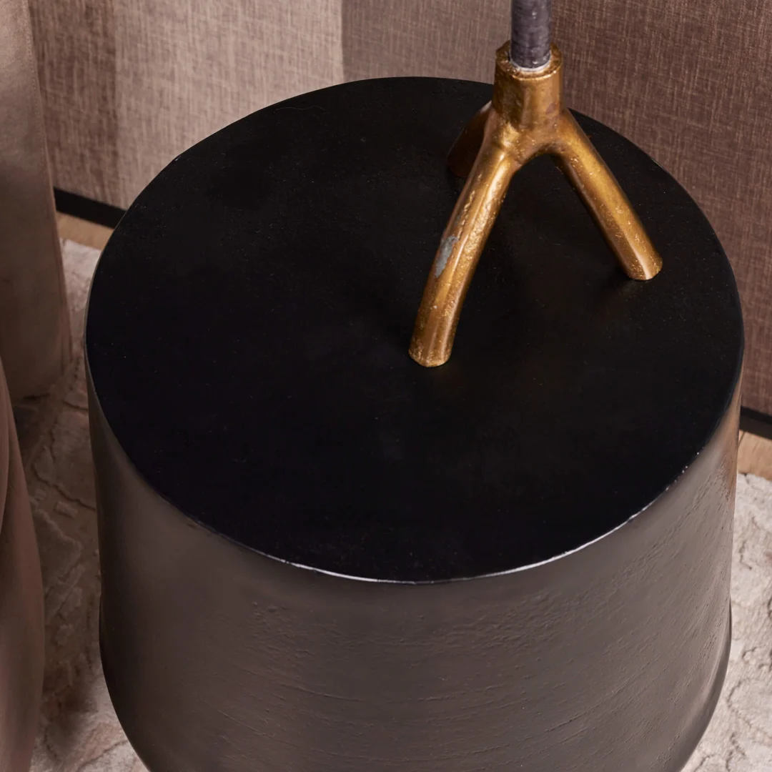 De bijzettafel Kacy heeft een rond zwart blad en een metallic gouden driepoot, perfect om een lamp of decor op te plaatsen. Plaats het op een licht tapijt in de buurt van bruine muren en meubels om de stijl van je kamer te versterken.