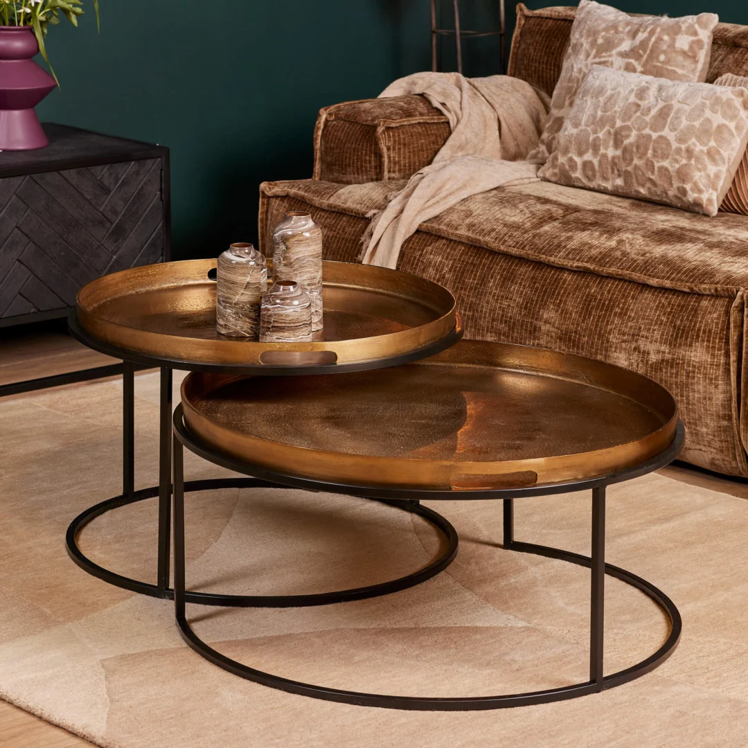 Een Vierkant Salontafel 78 x 37 CM met een metalen frame staat op een beige vloerkleed in de woonkamer. Bovenop staan twee decoratieve potten. Achter de tafel staat een bank met bruine structuur, kussens en een kleed.