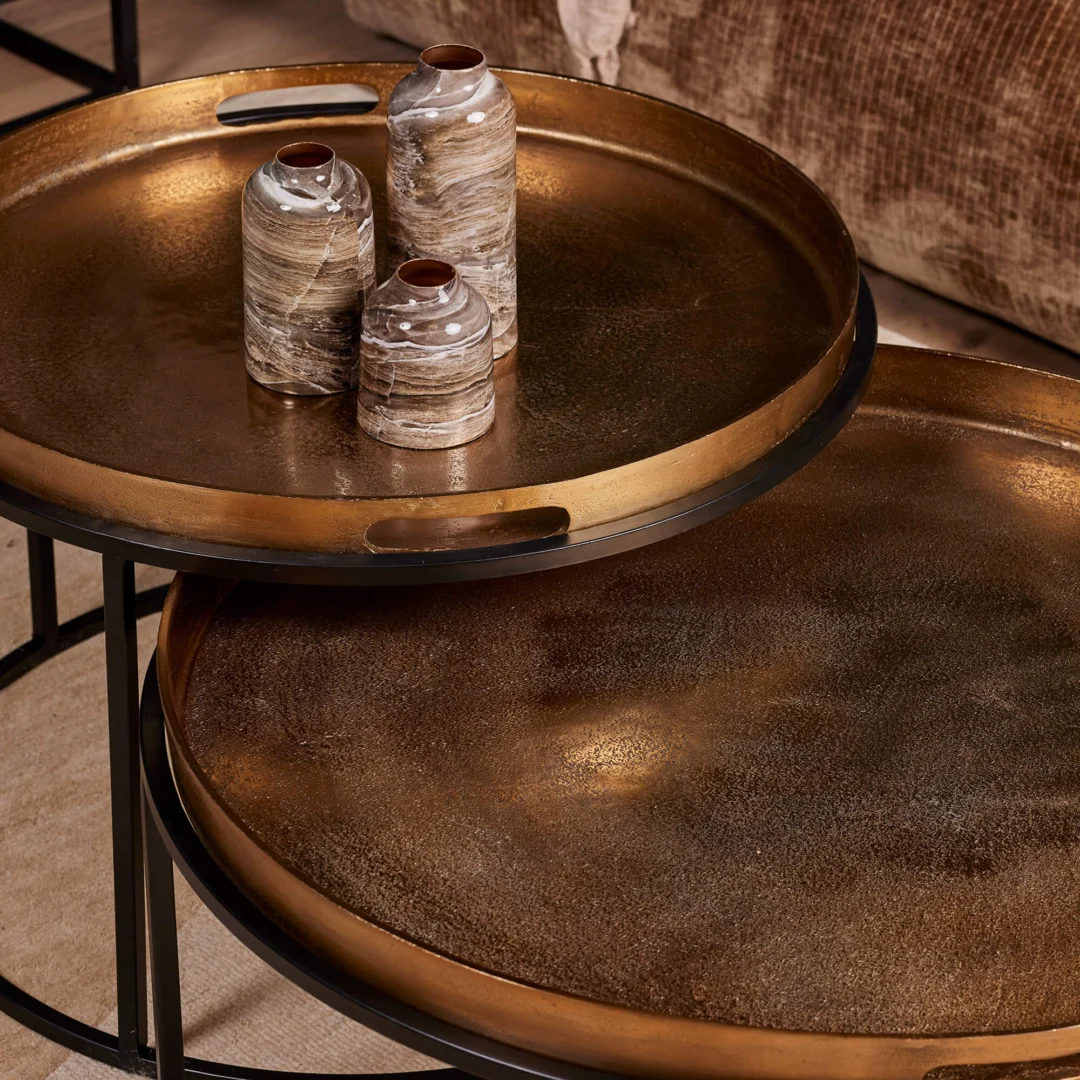 De Salontafel 78 x 37 CM Vierkant, een vierkante metalen nesttafel met opstaande randen en uitgesneden handgrepen, bevat drie gemarmerde keramieken vazen van verschillende hoogtes. Op de achtergrond is een bruin gestoffeerde stoel te zien.