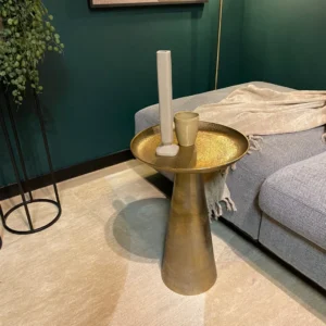 De Salontafel 40 x 40 CM Vierkant heeft een beige kopje en een hoog wit item naast een grijze bank met een beige kleed. Groene muren, een hangende plant en een crèmekleurig tapijt versterken de moderne woonkamer.
