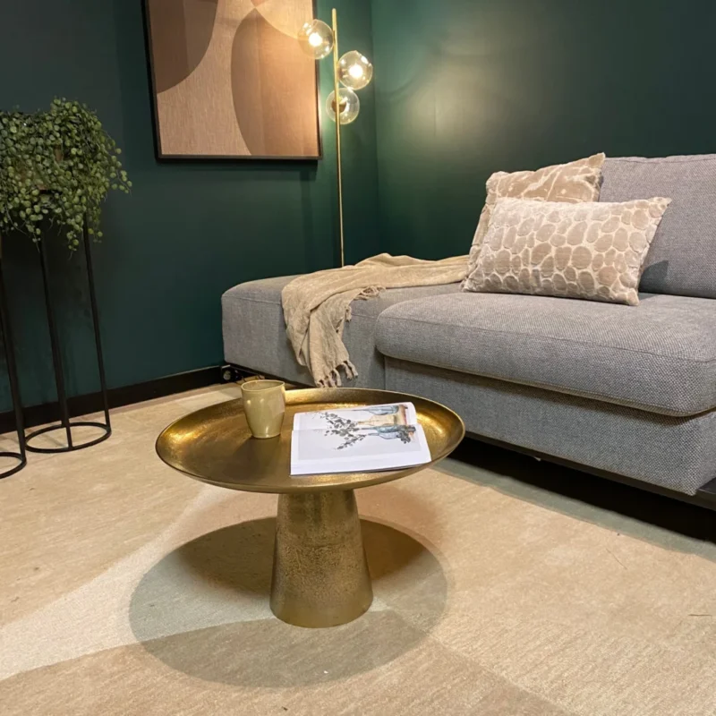 Een moderne woonkamer met een grijze bank, gedessineerde kussens, beige plaids, staande plant, abstracte muurkunst, staande lamp met drie lampen en de Salontafel 58 x 36 CM Vierkant met een mok en tijdschrift.
