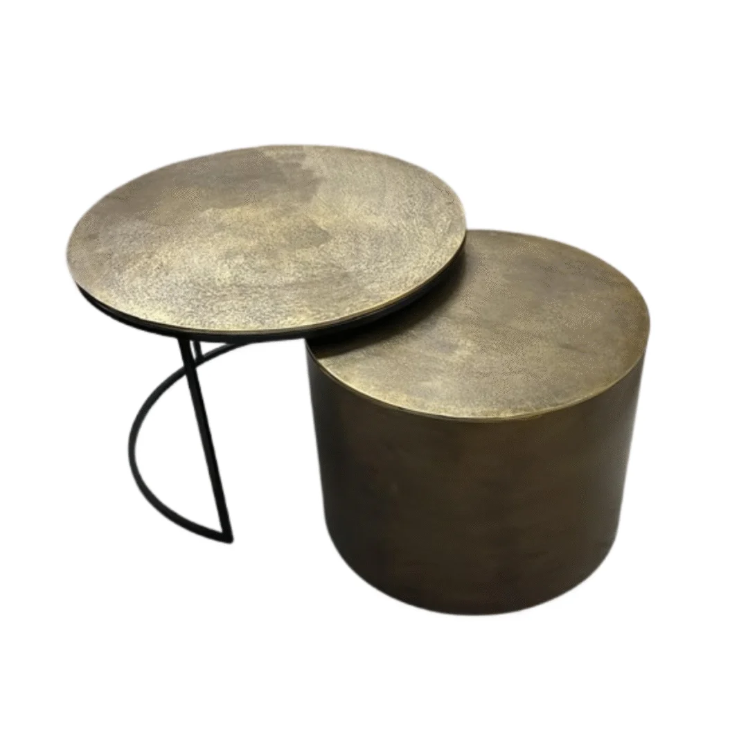 De Salontafel Goud set bestaat uit twee moderne nesttafels met ronde, metallic gouden bladen: een met dunne zwarte poten en een hoger profiel, de andere korter en cilindervormig, ontworpen om stijlvol te overlappen in elke ruimte.
