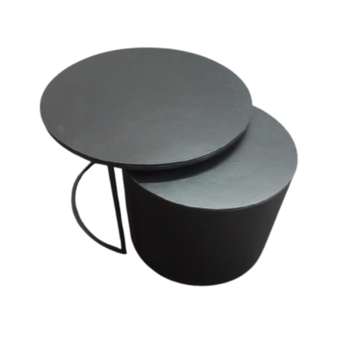 De Salontafel Zwart, Goud Rond Aluminium bestaat uit twee moderne ronde tafels met een strak ontwerp - de ene iets groter en overlappend met de kleinere - beide met een massief cilindrisch onderstel en een plat blad, tegen een witte achtergrond.