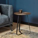 De Salontafel 40 x 50 CM Vierkant staat naast een grijze bank op een houten vloer tegen een blauwe muur. Een enkele donkere beker rust op de tafel, met een deel van een tapijt met patroon zichtbaar in de buurt.