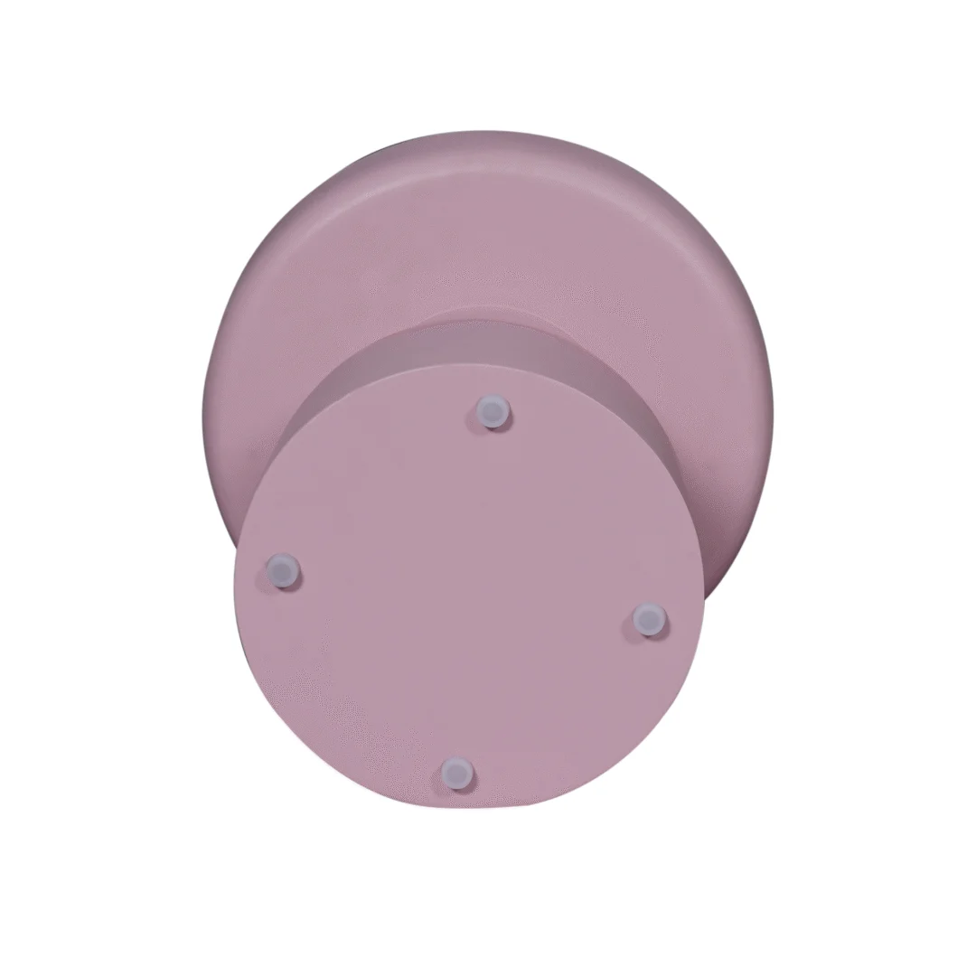 De bijzettafel Drum | Roze is een rond, licht mauve stuk met een kleinere ronde basis bevestigd aan een grotere achterplaat. Van voren gezien tegen een witte achtergrond zijn er vier kleine uitsteeksels gelijkmatig verdeeld over de basis.