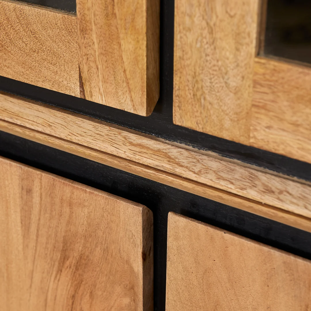Detailopname van de RichWood vitrinekast, met houten panelen en zwarte accenten. Het warme licht benadrukt de houtnerf en textuur.