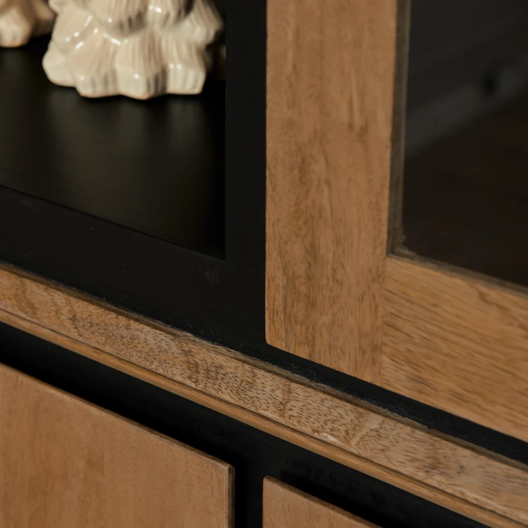 Detailopname van een RichWood vitrinekast, toont het hout en zwarte accenten. Zachte belichting benadrukt de textuur van het materiaal.