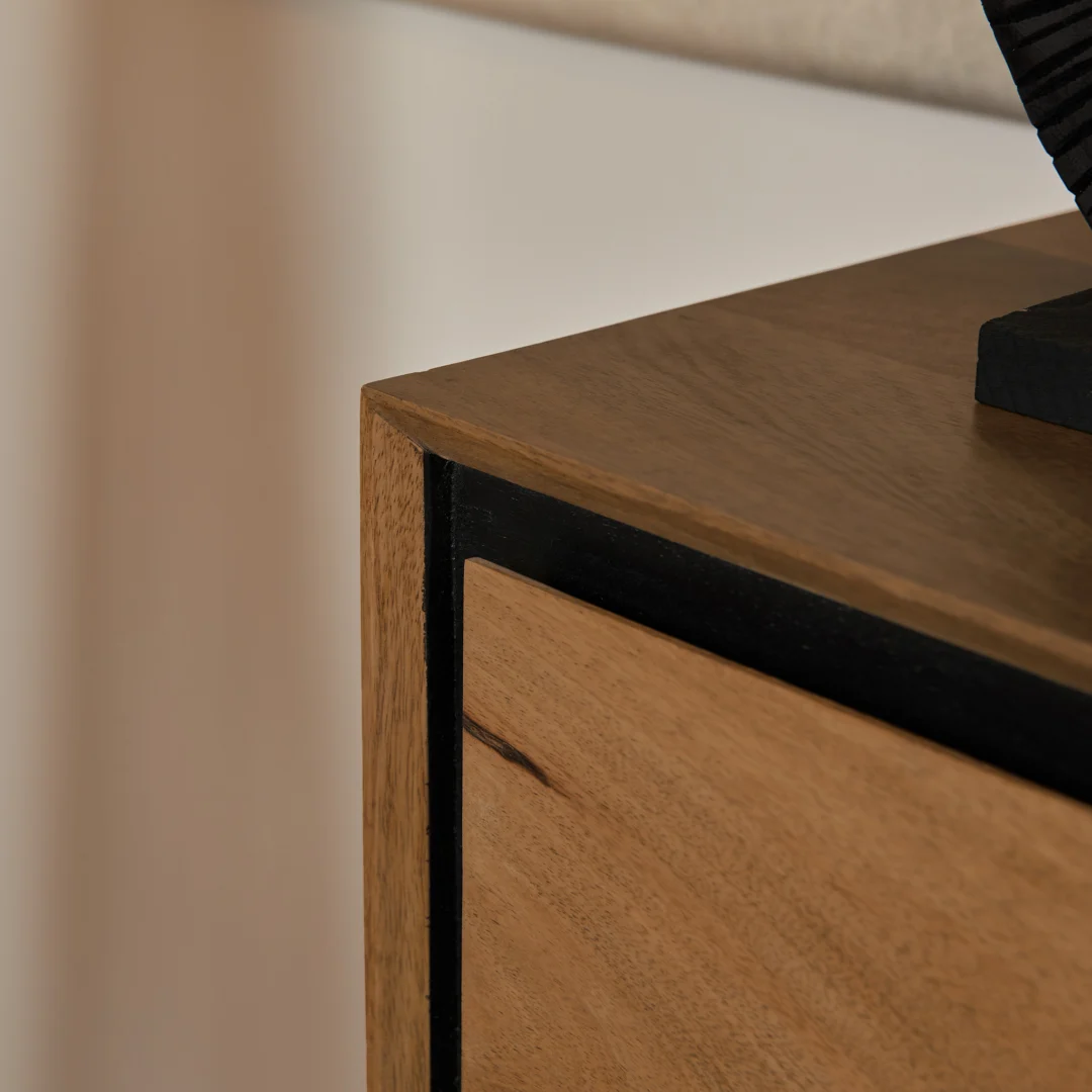 Detailopname van een RichWood sidetable, zijaanzicht. Houten oppervlakken in warme tinten, zwarte accenten. Neutrale achtergrond, zacht licht.