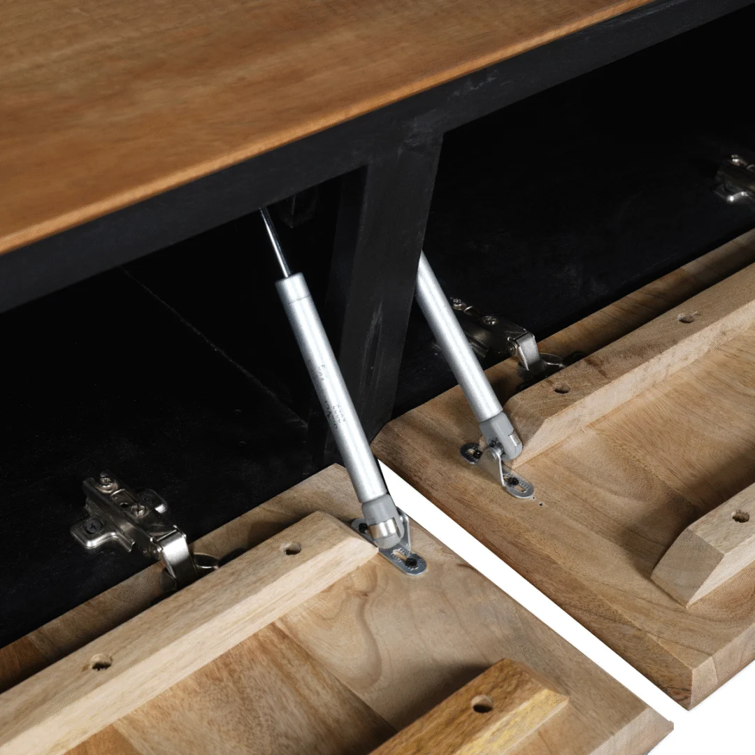 Detailopname van de binnenkant van een RichWood sidetable, met houten klep en metalen scharnieren, in natuurlijk licht. Zwarte achtergrond.