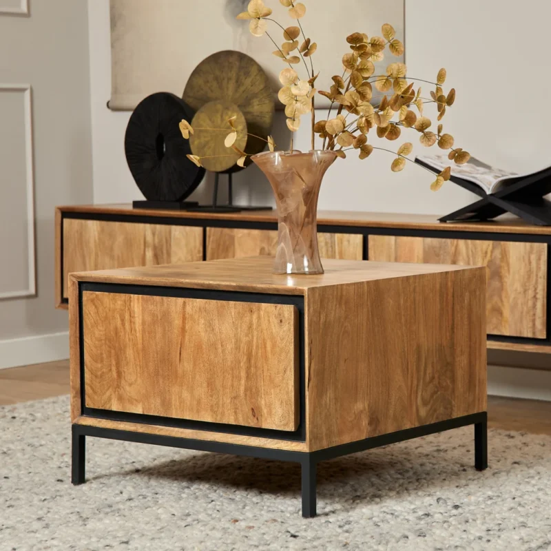 De Bijzettafel RichWood | 60 cm, een vierkante houten bijzettafel met zwart metalen poten, bevat een glazen vaas met gouden decoratieve takken. Op de achtergrond staat een bijpassende houten consoletafel met decor.