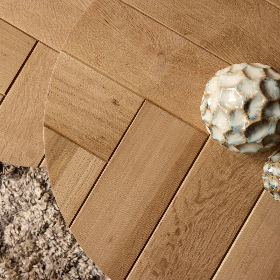 Bovenaanzicht van een houten salontafel met visgraatmotief, warme tinten. Decoratieve keramische bollen. Zachte belichting, detailrijk.