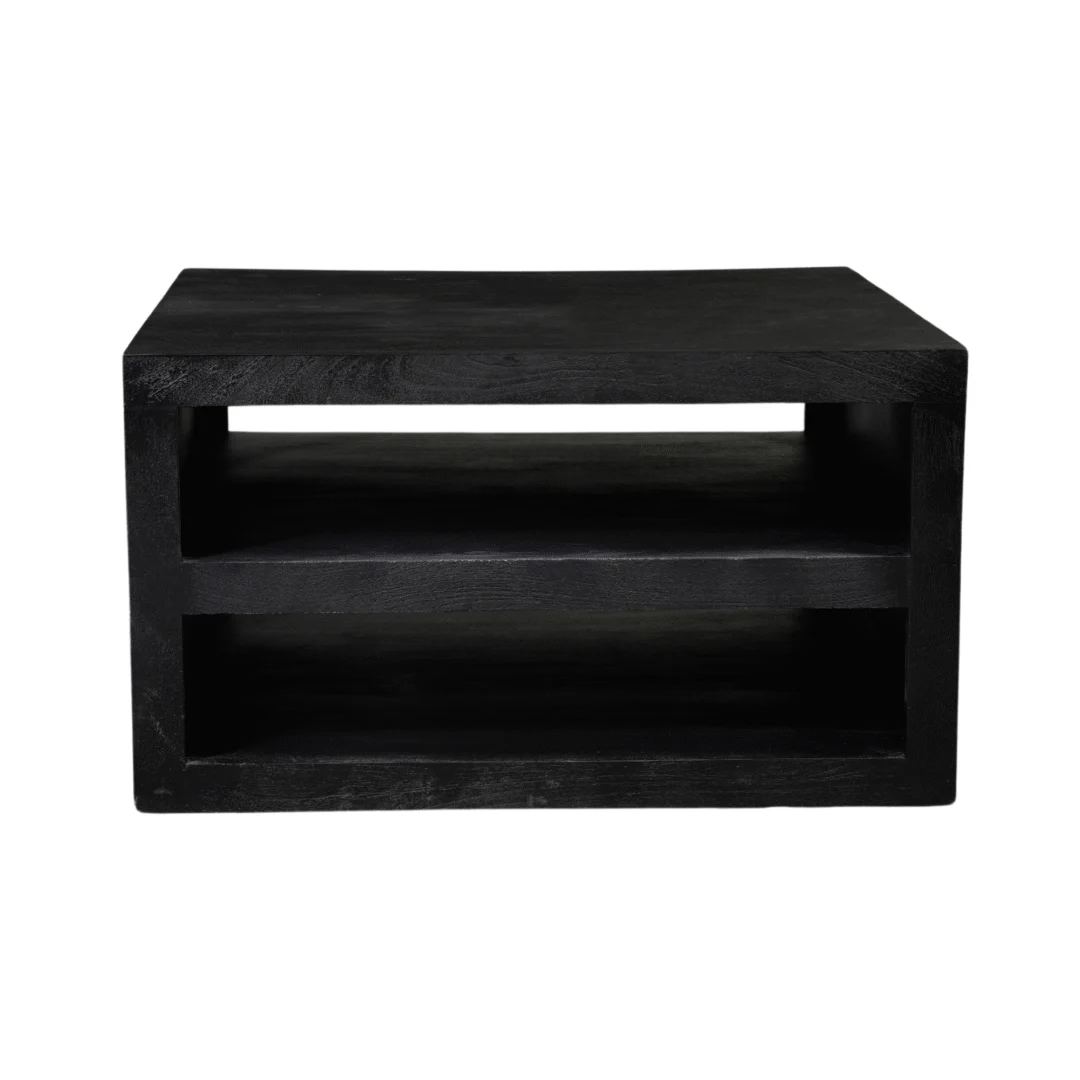 De Salontafel Zwart Design Tijdloos is een zwarte, rechthoekige houten tafel met twee open planken en een minimalistisch ontwerp, afgebeeld tegen een witte achtergrond.