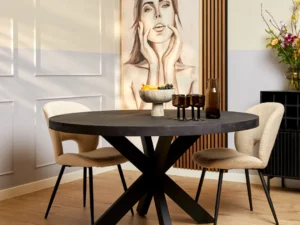 Een moderne eethoek met de Eettafel Denver Zwart (rond, 120 cm), twee beige gestoffeerde stoelen, decoratieve vazen, een fruitschaal en een groot vrouwenportret. Minimalistische decoratie en bloemen maken de stijlvolle look compleet.
