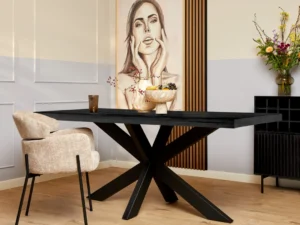 Een moderne eetkamer met de Eettafel Denver Zwart Rechthoek 240 cm, beige gestoffeerde stoelen, een fruitschaal, een drankje en een bloemenvaas. Achter de tafel staat een groot vrouwenportret en decoratieve houten lambrisering.