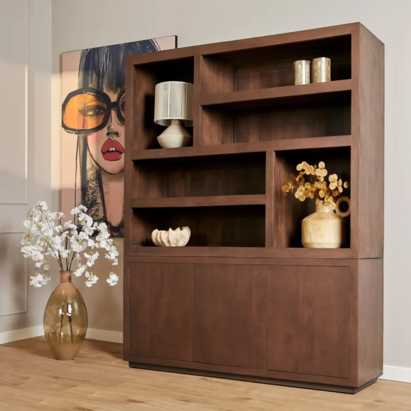 De Salontafel Walnoot Compact staat naast een grote vaas met witte bloemen en een stijlvol schilderij van een vrouw met een te grote bril, terwijl op houten planken vazen, boeken en een lamp staan voor een moderne inrichting.