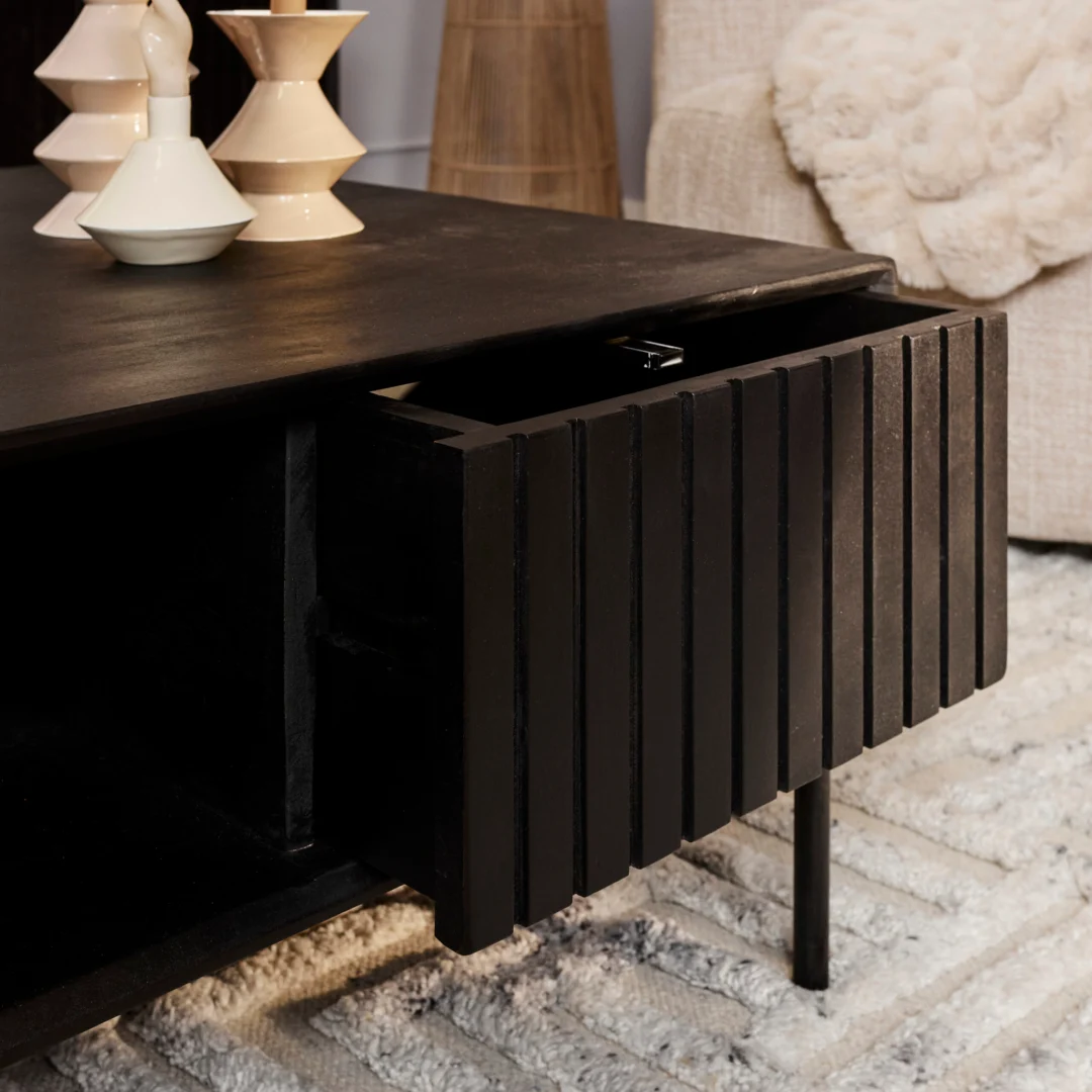 Een close-up van de Salontafel 80 x 80 CM Vierkant Opbergvak, een moderne zwarte salontafel met een gedeeltelijk open lade, gestileerd met vazen. Op de achtergrond liggen een vloerkleed met structuur en een gezellige bank.