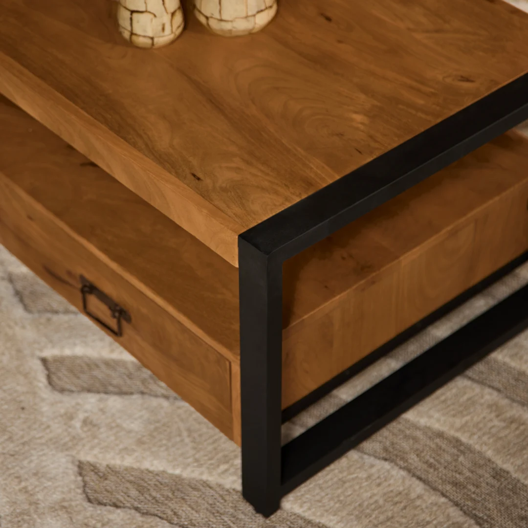 De Salontafel 120 x 60 CM Klassiek heeft een houten blad, een zwart metalen frame en een lade met metalen handvat. Hij staat op een beige en crèmekleurig tapijt met textuur, waarbij twee decoratieve objecten gedeeltelijk zichtbaar zijn op het tafelblad.