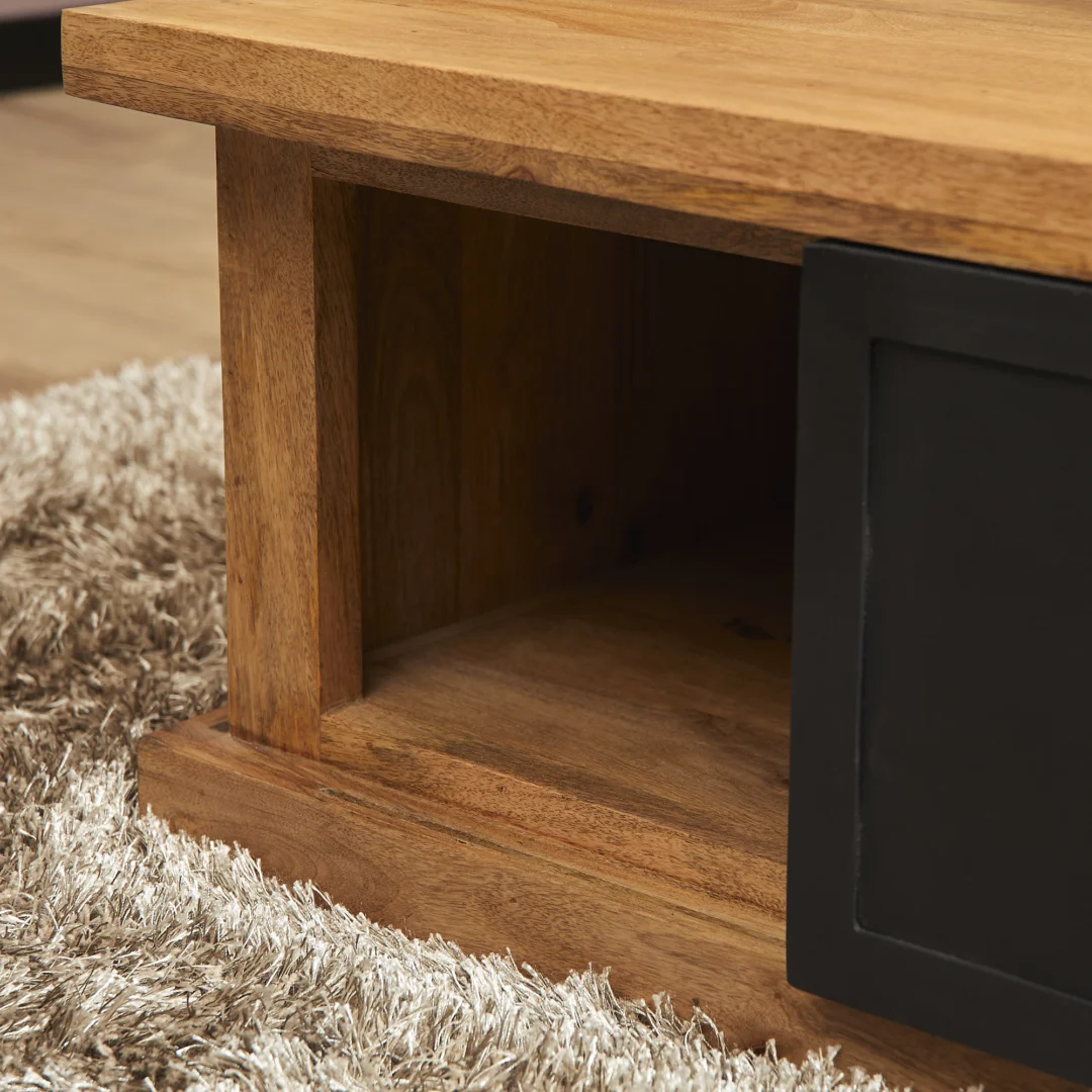 Een close-up van de Salontafel 80 CM Klassiek met een open rechthoekig compartiment en een zwarte schuifdeur, op een lichtbruin shaggy vloerkleed met textuur.