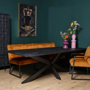 Een moderne eethoek met de Eettafel New York | Rechthoek | 200 cm zwarte tafel, mosterd fluwelen bank en stoel, groene muren, een goud en zwart portret, roze vazen met bloemen en een houten vloer.