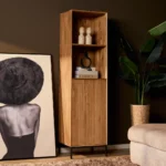 Houten boekenkast Madison in natuurlijk licht, met twee planken en een kastdeur met ribbels. Zwarte poten, sfeervolle belichting.