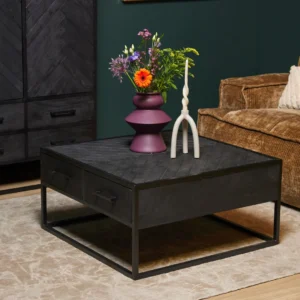 De Salontafel 80 x 80 CM Vierkant Compact met laden staat op een beige vloerkleed, met daarop een paarse vaas met gemengde bloemen en een moderne witte kandelaar. Op de achtergrond staan een bruine ribfluwelen bank en een donkere kast.