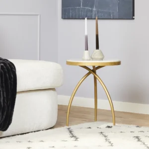 Een moderne woonkamer met een witte bank, een crèmekleurig vloerkleed met een zwart ruitpatroon en de Kay bijzettafel van wit marmer (40 cm) met twee geometrische kandelaars. Boven de lichtgrijze muur hangt een donker abstract kunstwerk.