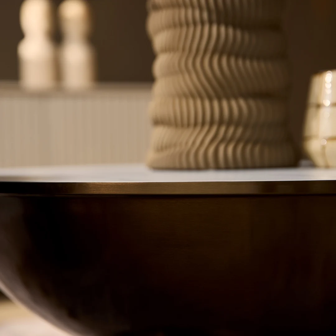 Een close-up van de Salontafel Opbergvak, gestyled met een golvende beige vaas, een klein kopje en vaag decor op de achtergrond, alles in warme, neutrale tinten.