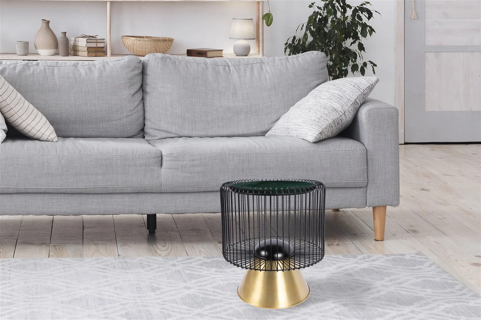 Een moderne woonkamer met een lichtgrijze bank, een vloerkleed met patroon en de Bijzettafel Zwart, Groen 40 CM Rond-een ronde zwart en groen marmeren bijzettafel. Planken, decor en een groene plant sieren de achtergrond.