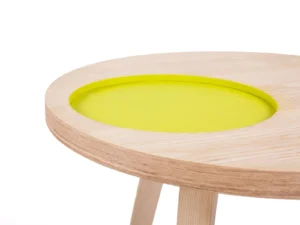 Een close-up van de Bijzettafel Groen Rond Mdf, een minimalistische ronde tafel met lichthouten poten en een verzonken rond blad met een helder geelgroen oppervlak.