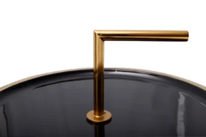 Een close-up van de Bijzettafel Zwart 13 CM Rond Ijzer, met een zwart rond tafelblad met een glanzend gouden metalen handvat en een opbergvak, geïsoleerd op een witte achtergrond.