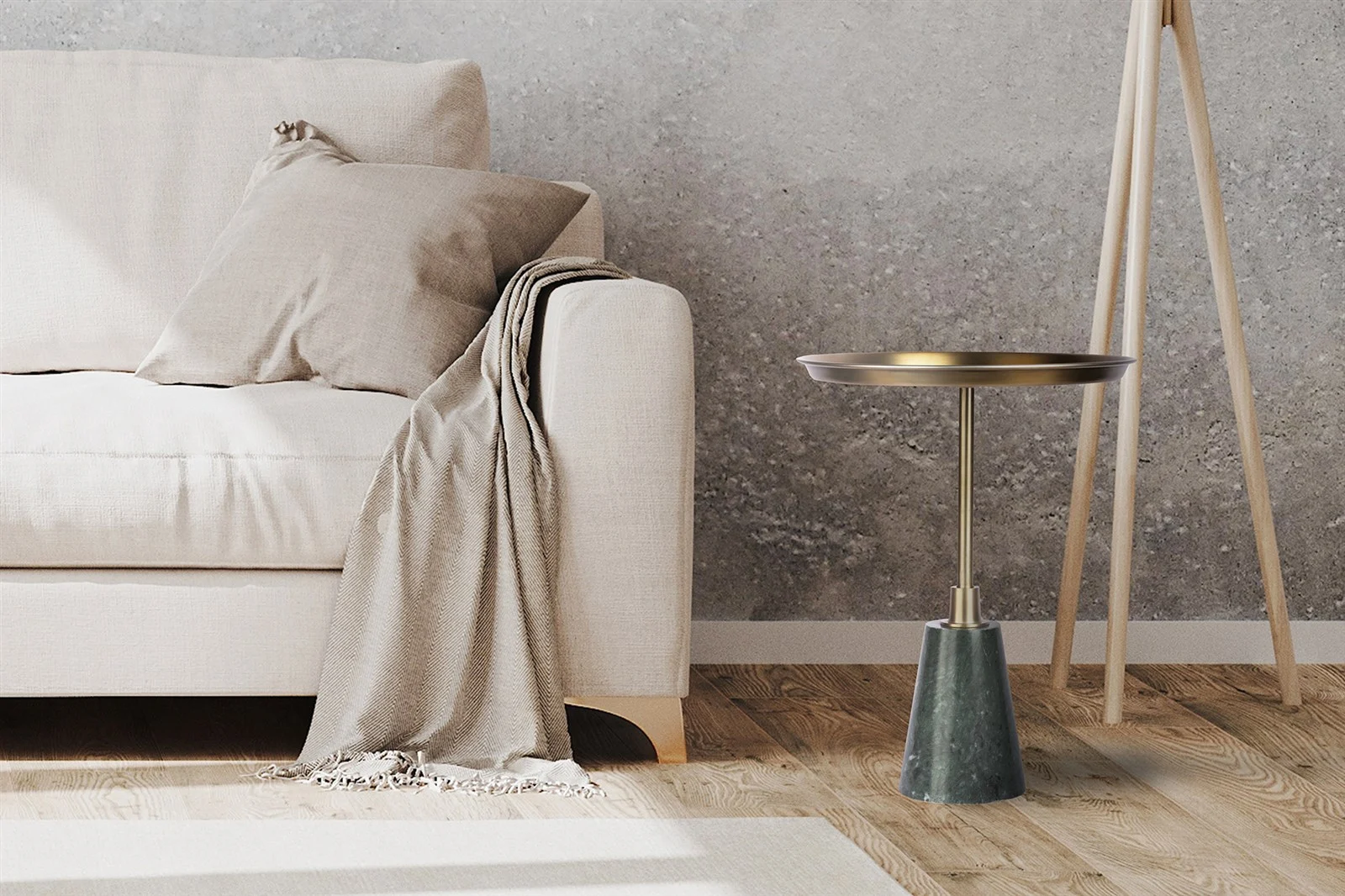 Een beige bank met een bijpassend kleed en kussen staat naast de Bijzettafel Zwart, een ronde bijzettafel van roestkleurig aluminium, allemaal geplaatst op een houten vloer tegen een grijze muur met structuur.