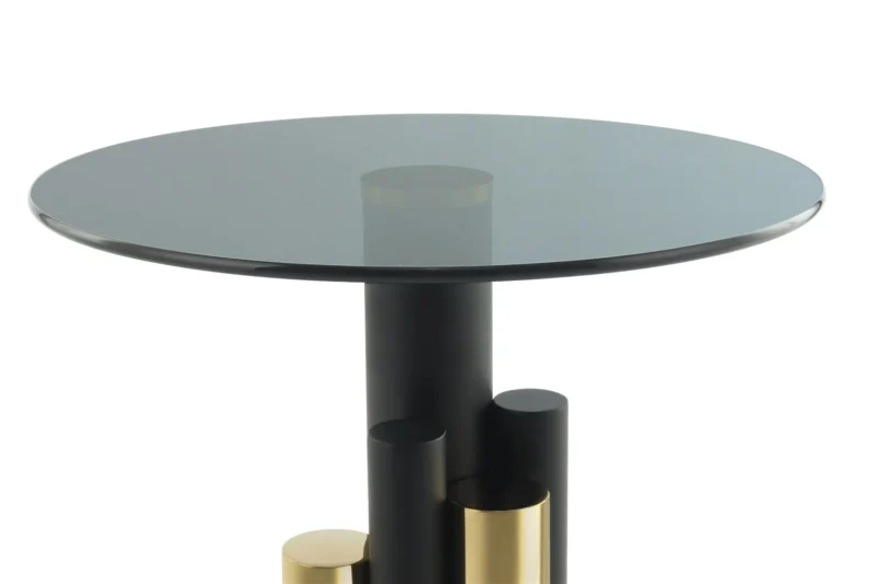 De Bijzettafel Grijs, Goud Aluminium is een moderne bijzettafel met een rond glazen blad en een opvallend onderstel van zwart en goud aluminium cilindervormige steunen in verschillende hoogtes.
