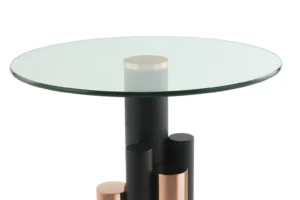 De Bijzettafel Aluminium is een moderne ronde glazen bijzettafel met een onderstel van zwart en koper aluminium cilindrische kolommen in verschillende hoogtes.