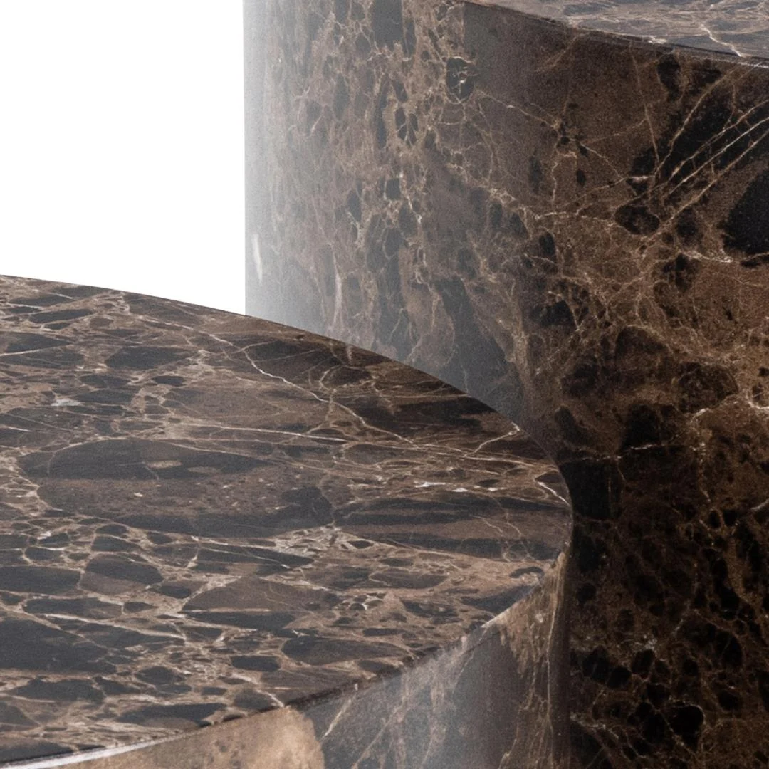 Detailopname van een bruine salontafel met marmerpatroon. Het oppervlak is glanzend en reflecteert het licht. Minimalistisch design.