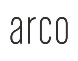Het Arco logo in donkergrijze letters tegen een witte achtergrond. Minimalistisch design voor woontrends.