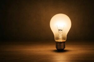 Gloeiende lamp op houten tafel, zacht licht. De lamp heeft het opschrift GOW. Sfeervolle verlichting voor een comfortabele woonkamer.