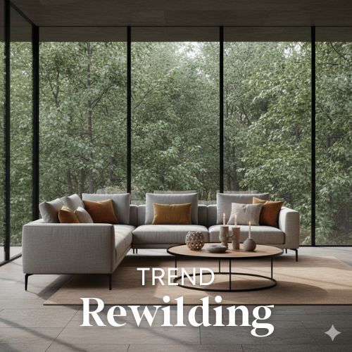 Lichte hoekbank met kussens en ronde tafel, voor een groot raam met bos. De woontrend is rewilding, natuurlijke materialen en kleuren.