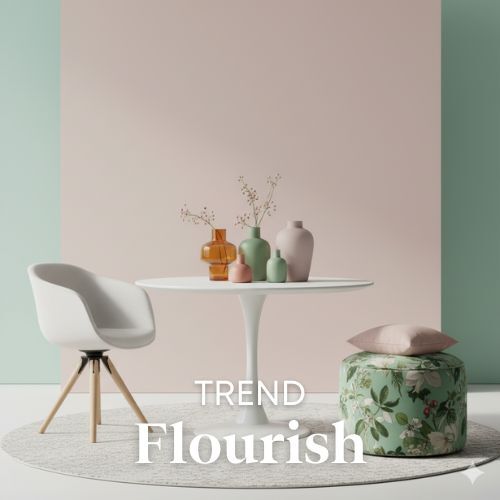 Lichte woontrend met ronde tafel, witte stoel en groen kussen. Zachte kleuren en natuurlijk licht. Vazen in pastelkleuren op tafel.