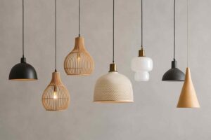 Zeven hanglampen in diverse stijlen en materialen. Houten latten, wit glas en zwart metaal tegen een zacht grijze achtergrond. Design woonkamer.