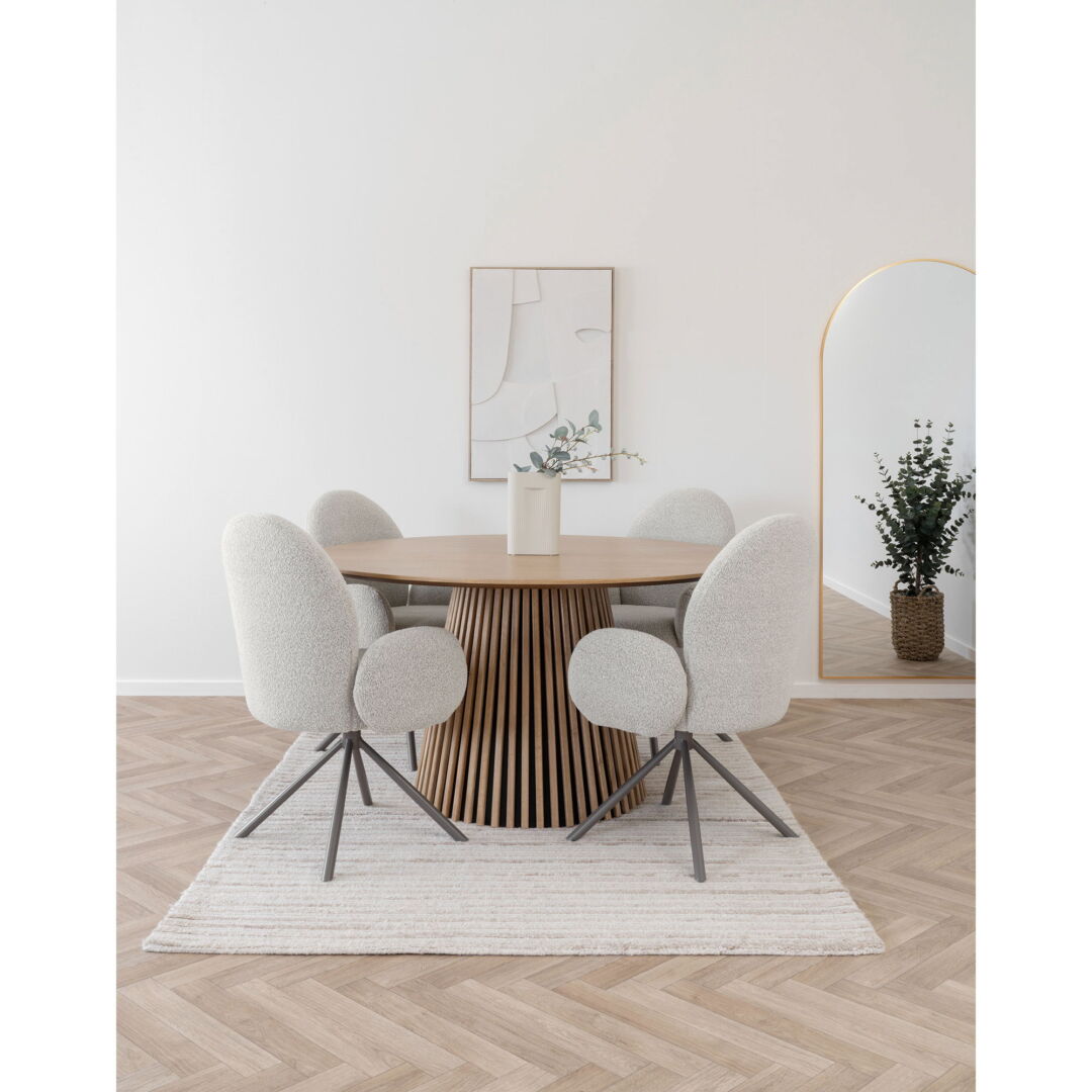 Lana Dining Chair set rondom houten tafel met design onderstel, zachte stoffering, minimalistische kunst aan de muur en spiegel.