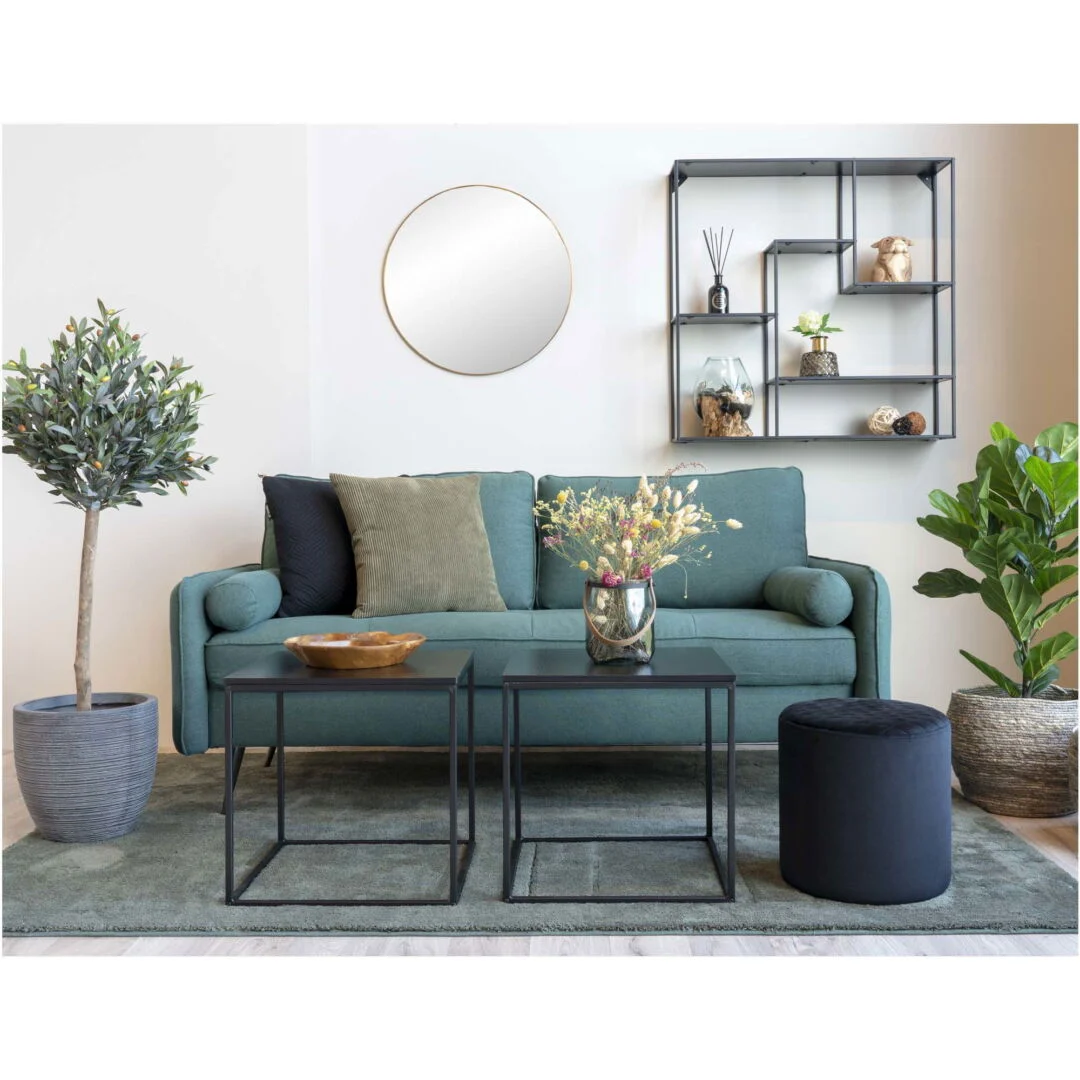 Living room scene featuring two square black bijzettafels (side tables) with a teal couch, round mirror, shelving unit, and plants. Neutraal, warme kleuren.