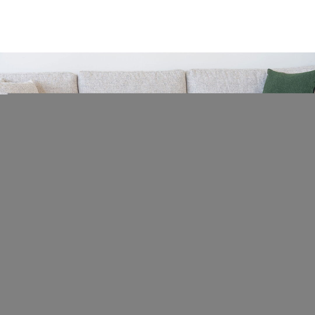 Beige sofa met groene kussen bovenaanzicht. Zachte bekleding en minimalistische stijl. Heldere verlichting, rustige achtergrond. Modern interieur.