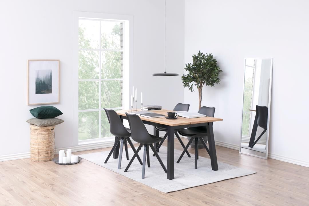 Dima eetkamerstoel (set van 2): Zwarte eetkamerstoelen aan een houten eettafel in een lichte eetkamer.