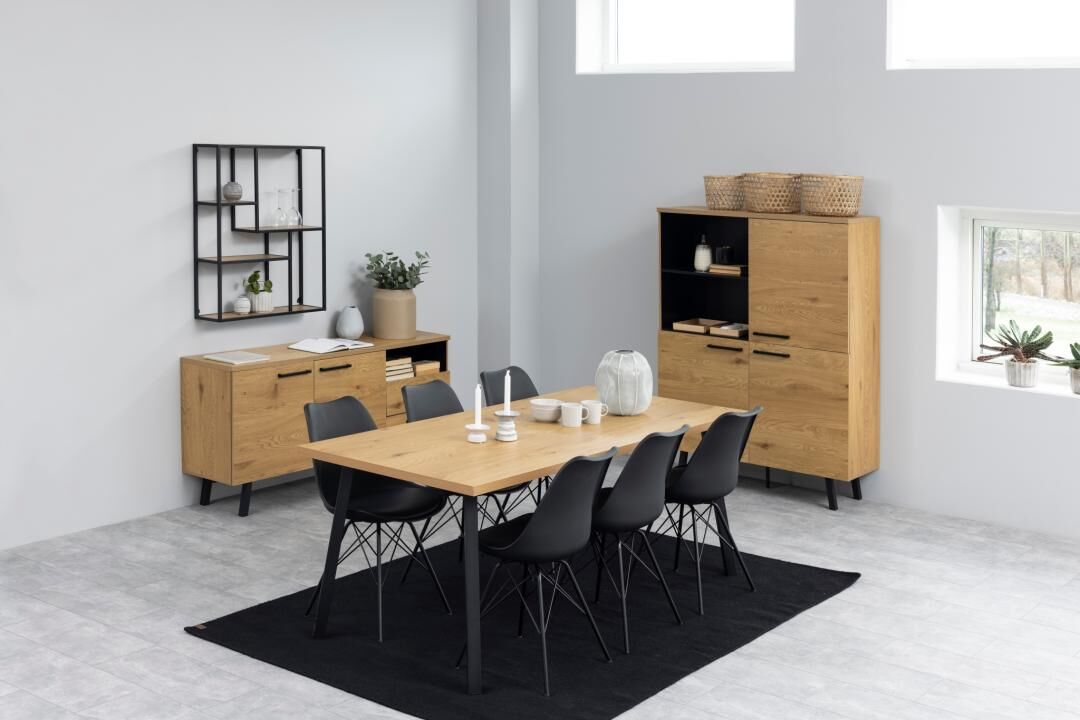 Eetkamer met houten tafel, zwarte Eris eetkamerstoelen (set van 2), zwart vloerkleed en houten kasten.