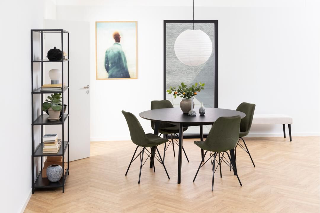 Eris eetkamerstoel (set van 2) aan een ronde, zwarte eettafel in een lichte kamer.