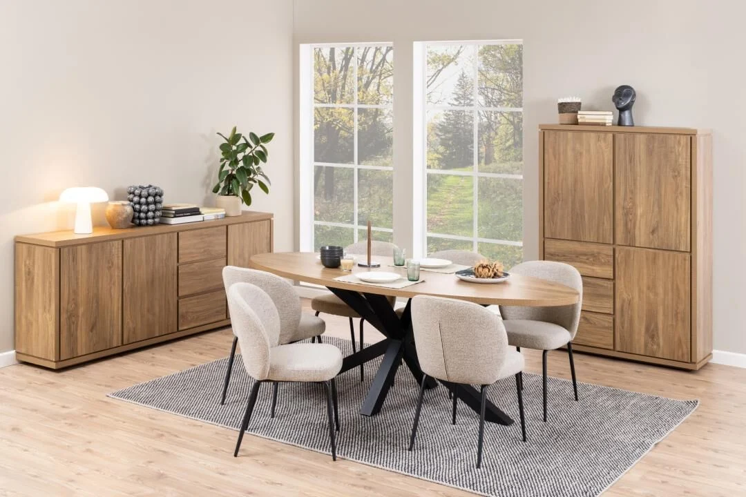 Eetkamer met ovale tafel, vier Patricia eetkamerstoelen, dressoir en kast bij een raam.