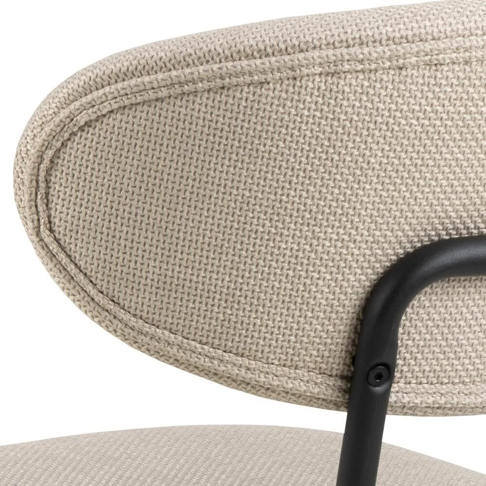 Detailopname Denise eetkamerstoel: zachte stoffen bekleding en zwart frame.
