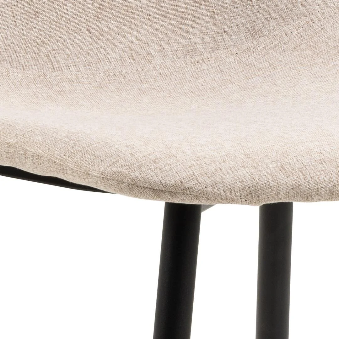 Celia eetkamerstoel: Detail van de zitting met beige stof en zwarte poten.